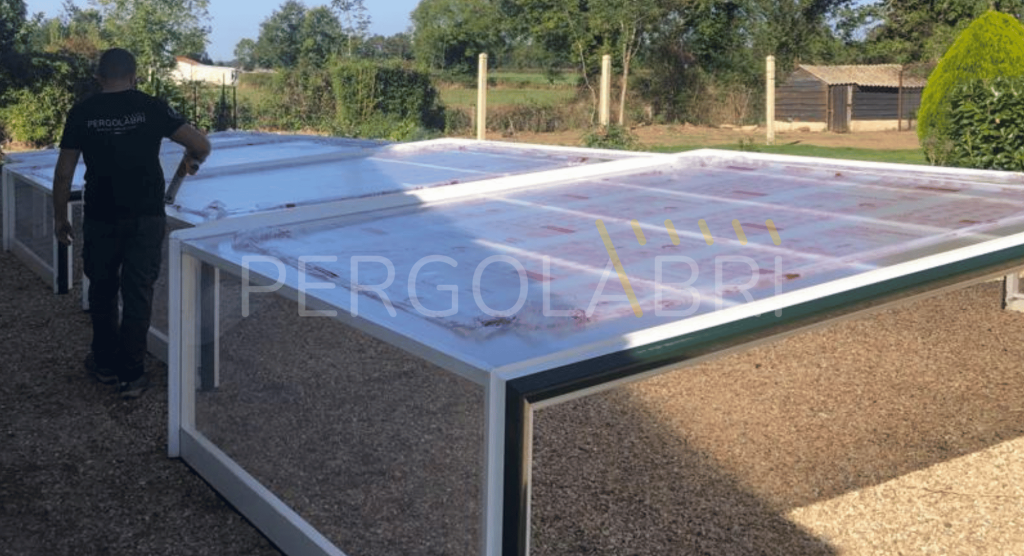 Nouvelles plaques de polycarbonate posées sur un abri de piscine Eureka, film de protection en place