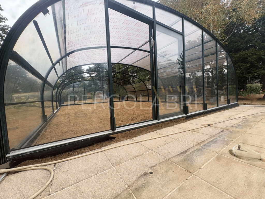Remplacement d'une plaque latérale transparente sur un abri de piscine.