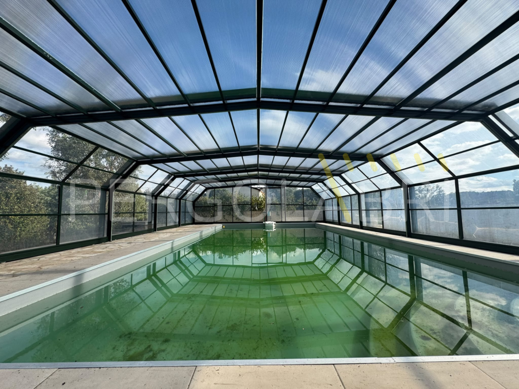 Piscine protégée par un abri haut vert sapin réparé à Soustons