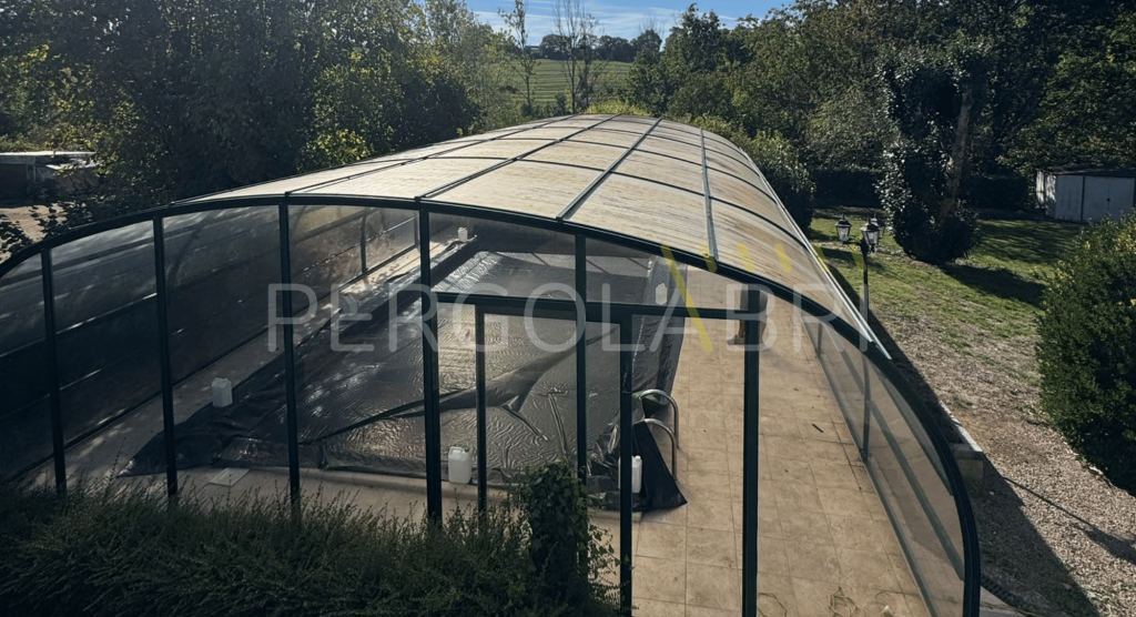 Plaques de polycarbonate vieillissantes sur la toiture d’un abri de piscine