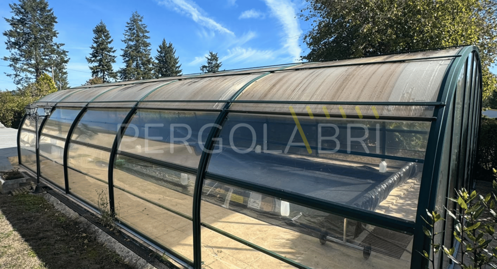 Plaques de polycarbonate vieillissantes sur la toiture d’un abri de piscine